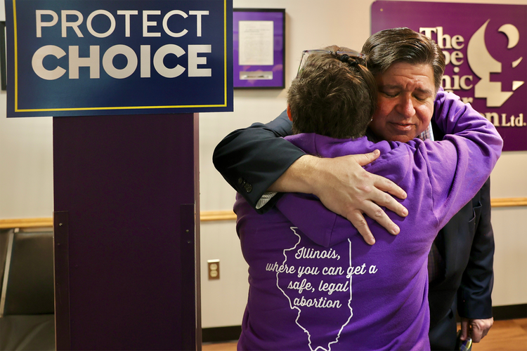 Gov. Pritzker hugs a supporter.