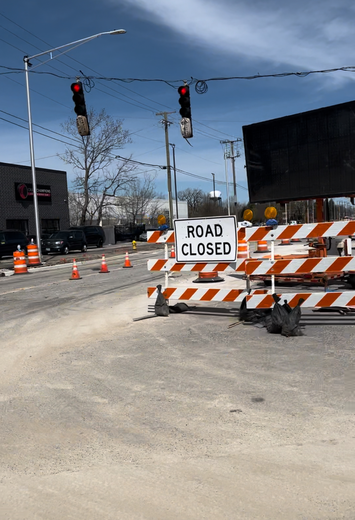 Road closed sign under red traffic signal